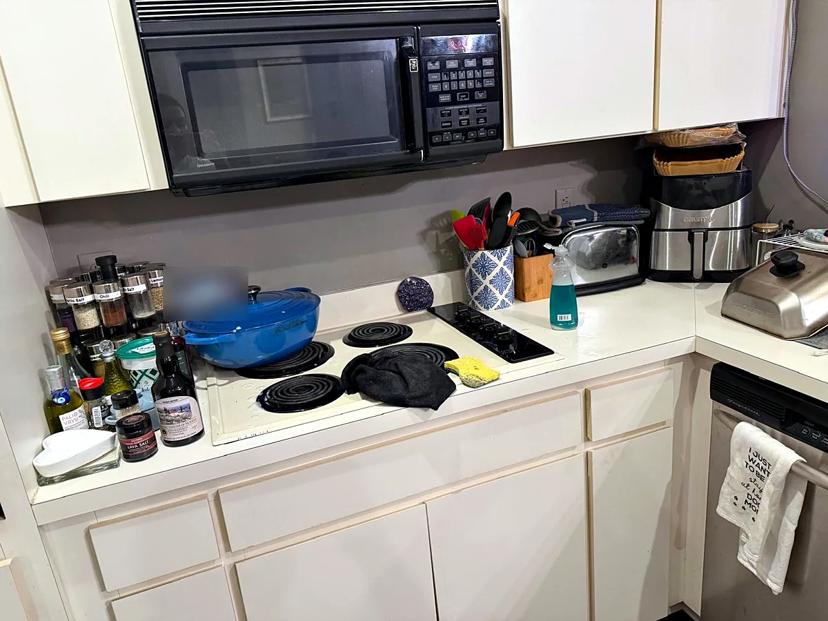 Cluttered stovetop with dish towel, sponge and spills before a Pure Perfection house cleaning